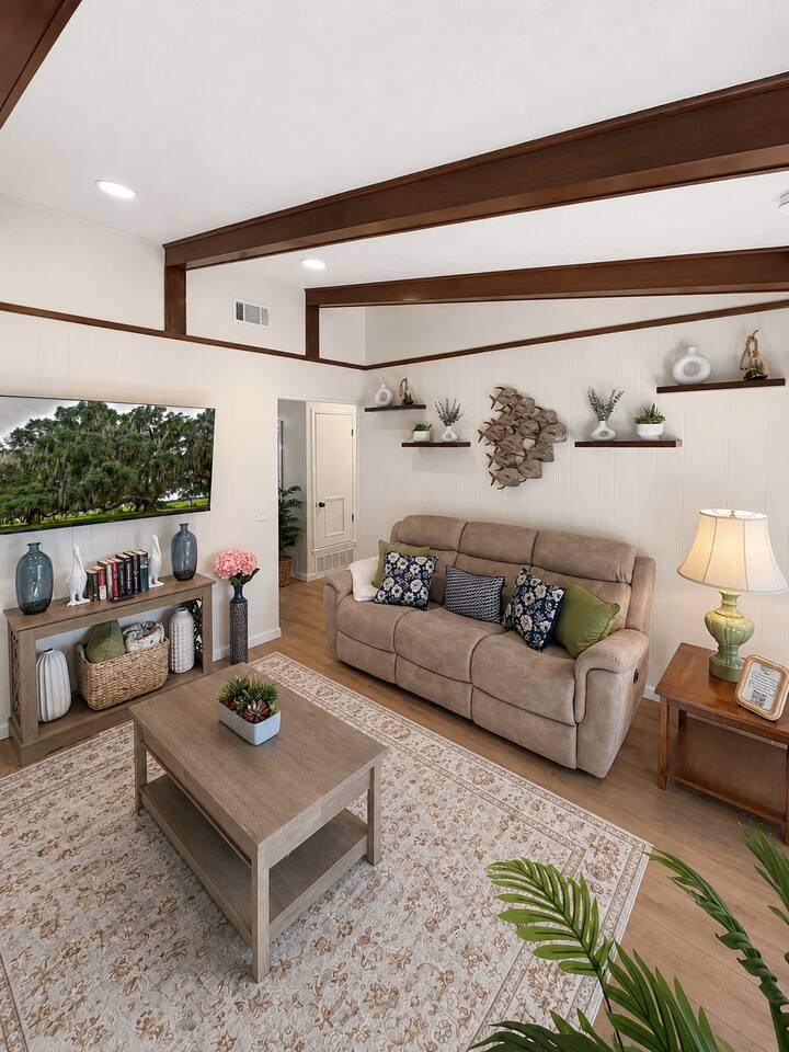 Sunlit den with exposed beams, reclining sofa and coffee table, Ms. Hattie's favorite room
