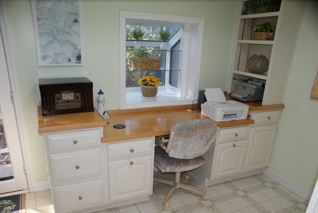 Built-in office desk with printer and window view of the garden