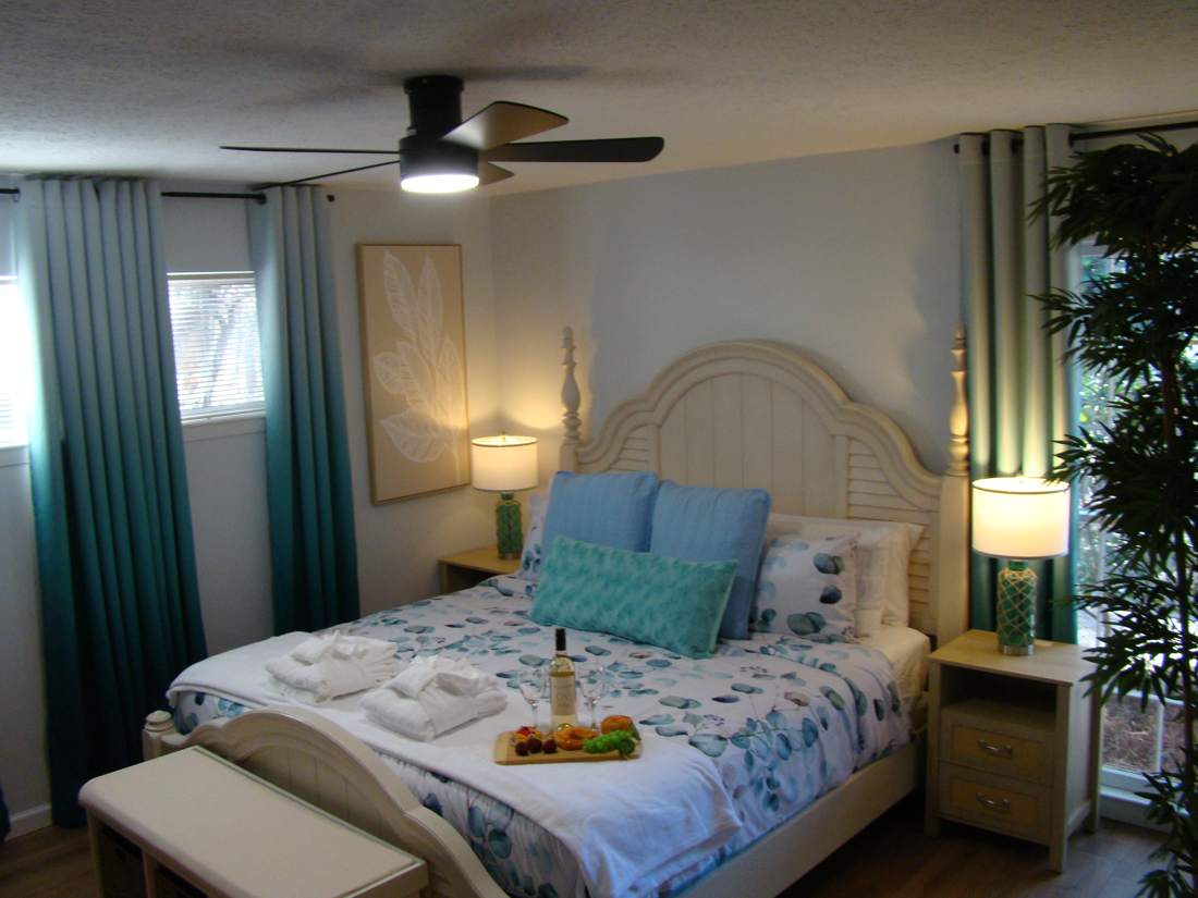 Primary bedroom with a plush bed and coastal decor
