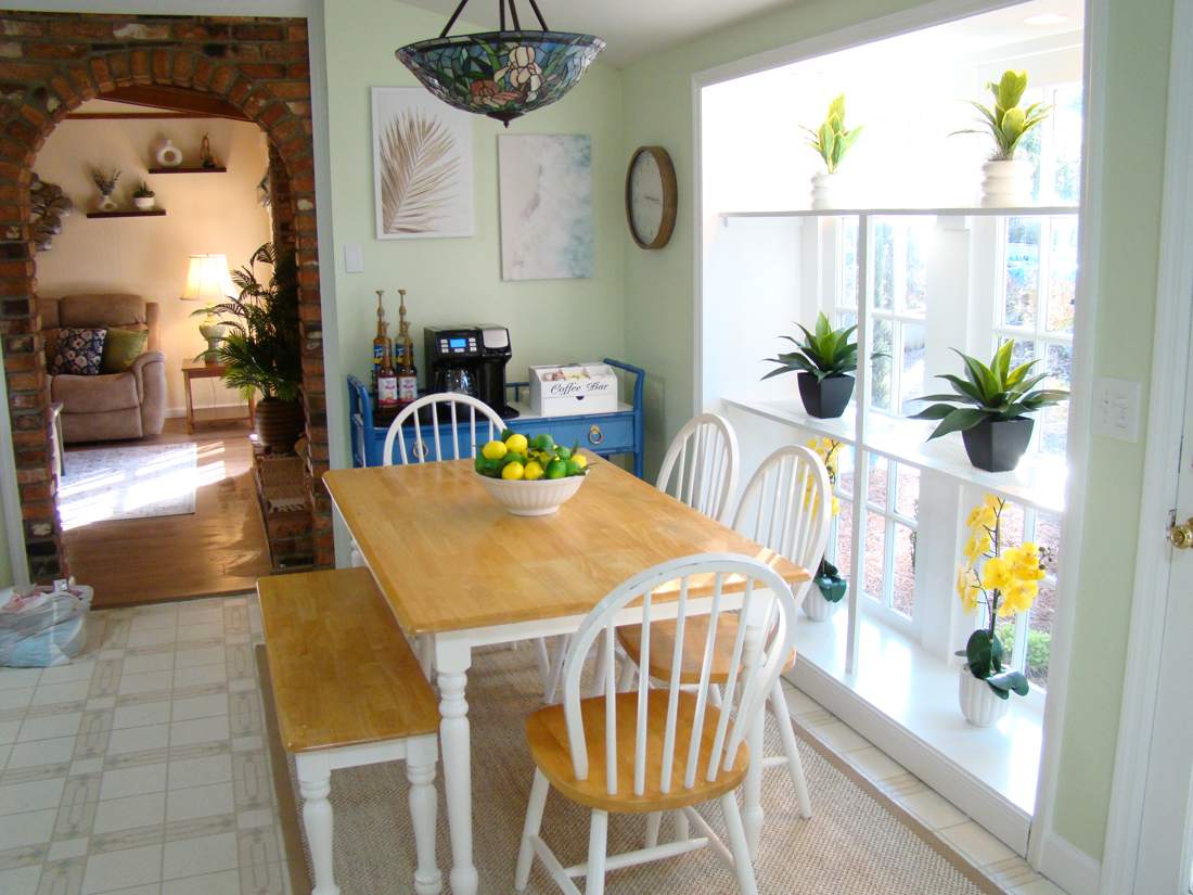 Sunny breakfast nook with farmhouse table and coffee bar